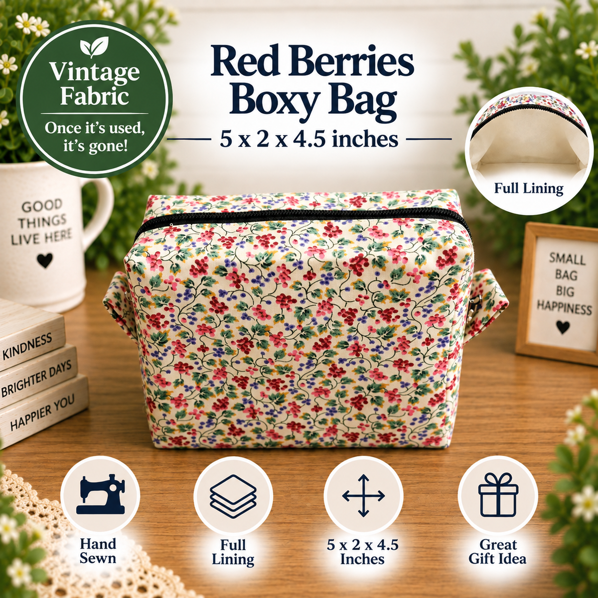 A floral boxy bag made from vintage-style fabric, displayed on a wooden surface with decorative props. The bag features a red, pink, and green floral pattern on a cream background.