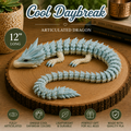 A 12-inch articulated dragon figurine in light blue and cream, displayed on a round wooden slice. The image features promotional text overlays including 'Cool Daybreak', 'Articulated Dragon', and '12" LONG', along with feature icons at the bottom.