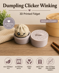 A 3D printed dumpling-shaped clicker winking from the side, shown next to its round base and lid on a wooden tabletop. The product is labeled 'Dumpling Clicker Winking' and 'Morandi Steamer,' with icons at the bottom highlighting eco-friendly PLA material and kid-friendly design.