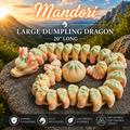 A set of pastel green and peach flexible dragon-shaped dumpling toys arranged in a circle on a large rock, with a mountain landscape background and text reading 'Mandori Large Dumpling Dragon 20" Long' plus feature icons at the bottom.