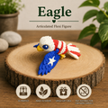 A 3D-printed articulated eagle flexi figure with a white head, red and white striped body, and blue wing with a white star, displayed on a round wood slice background. The image includes text overlays reading 'Eagle Articulated Flexi Figure' and four circular icons at the bottom highlighting product features.