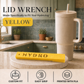 A yellow lid wrench tool displayed on a round stone coaster in a kitchen setting, next to a beige HydroJug tumbler with a straw. The image includes text overlays reading 'LID WRENCH', 'Made Specifically to Fit Your HydroJug', 'YELLOW', and feature icons at the bottom.