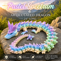 Pastel Spectrum articulated dragon toy arranged in a heart shape on a large rock outdoors, with mountains and grass visible in the background. Text at the top reads 'Pastel Spectrum Articulated Dragon 24" Long,' and feature icons at the bottom mention durable PLA material, fully articulated design, lightweight and flexible, and not suitable for children under 3.