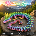 A rainbow-colored articulated dragon toy posed on a large rock outdoors, with mountain scenery in the background and text reading 'Northern Lights Articulated Dragon 24" Long' plus feature icons along the bottom.