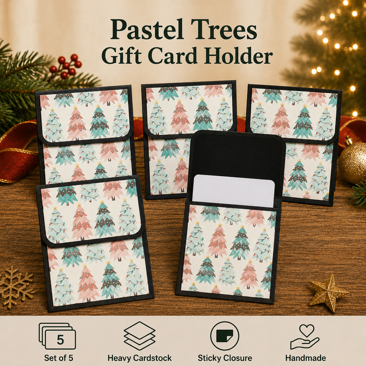Five pastel tree-patterned gift card holders arranged on a wooden surface with holiday decorations in the background. One holder is open to show the interior and sticky closure.