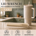 A tan lid wrench tool displayed on a marble cutting board next to a matching textured beige HydroJug travel tumbler with a straw in a kitchen setting. The image includes text overlays describing the product and feature icons at the bottom.