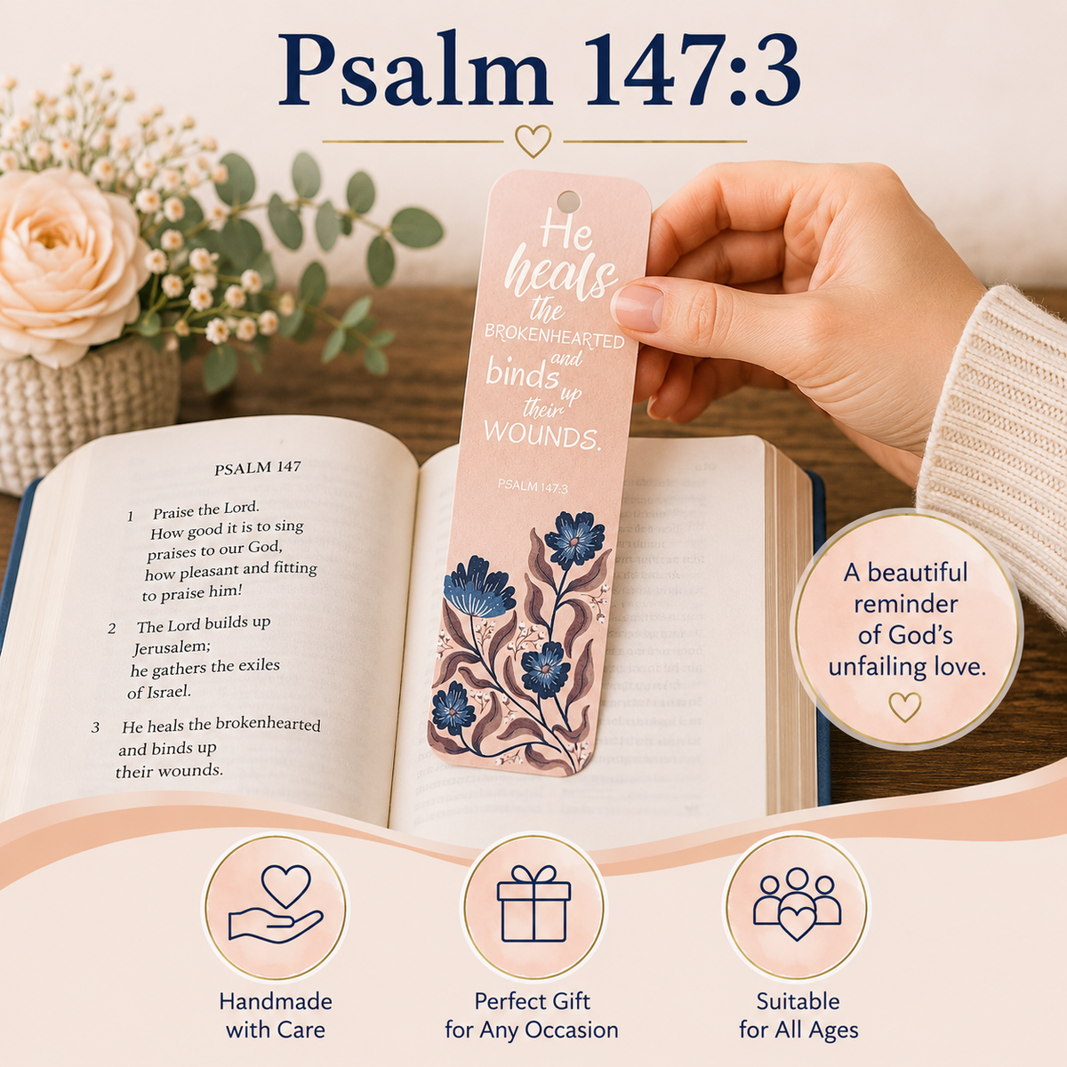 A hand holds a pink bookmark shaped like a book page with blue floral illustrations and the text 'He heals the brokenhearted and binds up wounds' from Psalm 147:3. The scene is styled over an open Bible with additional decorative flowers and a soft promotional background, plus text callouts highlighting handmade care, gift suitability, and use for all ages.