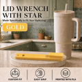 A gold lid wrench with a star-shaped socket is displayed on a marble trivet in a kitchen setting, next to a beige HydroJug tumbler. The image includes text overlays reading 'LID WRENCH WITH STAR', 'Made Specifically to Fit Your HydroJug', 'GOLD', and feature icons at the bottom.