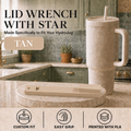A tan lid wrench with a star-shaped tip is displayed on a round wooden stand on a kitchen countertop, next to a matching insulated tumbler with a straw. The image includes text reading 'LID WRENCH WITH STAR' and 'TAN', plus feature icons at the bottom.