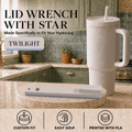 A lid wrench with a star-shaped tip is displayed on a round wooden coaster in a kitchen setting, next to a white HydroJug travel tumbler. The image includes text overlays describing the product as 'TWILIGHT' and features three icons at the bottom highlighting custom fit, easy grip, and PLA printing.