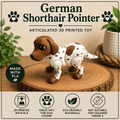 A 3D-printed articulated German Shorthair Pointer dog toy displayed on a round wood slice. The toy features a brown head and ears with a white body and brown spots.